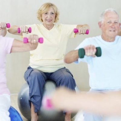 A group of elderly people lifting weights together in a fitness class